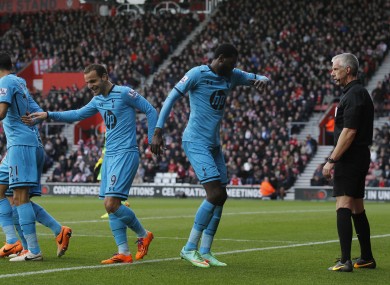 Referee Chris Foy watches Adebayor celebrate his second goal.